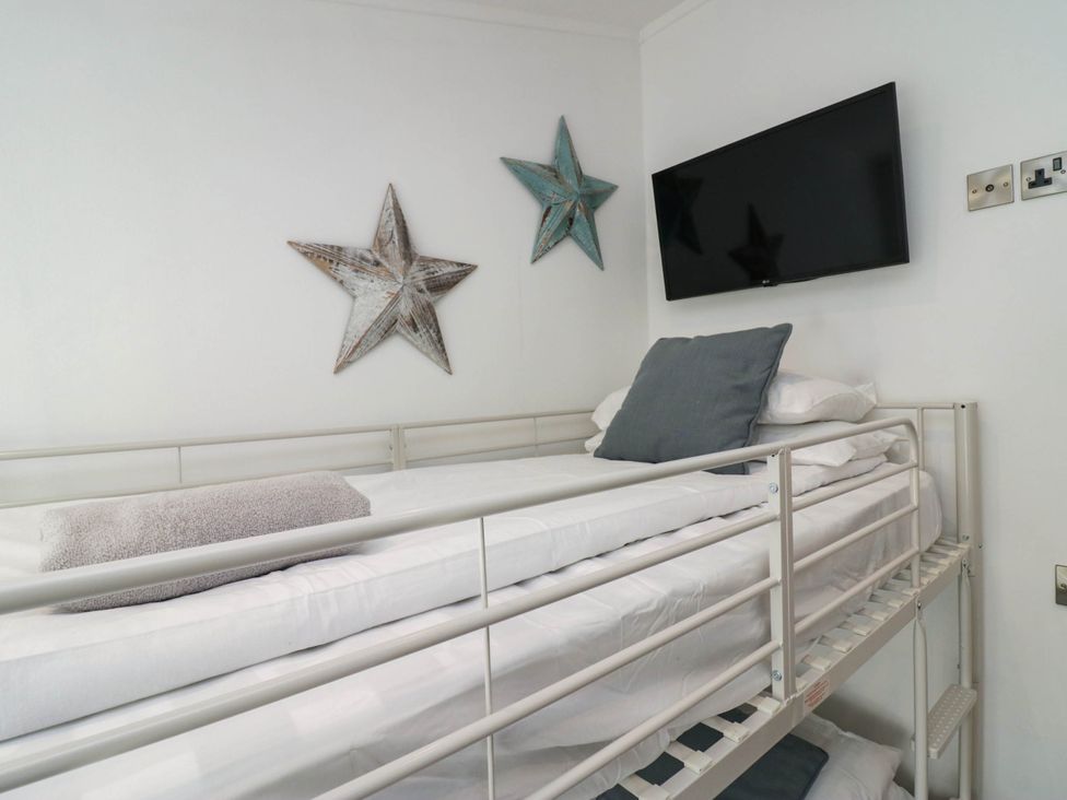 A bunk bed with pillows and a TV at Thirlmere Scar in Windermere