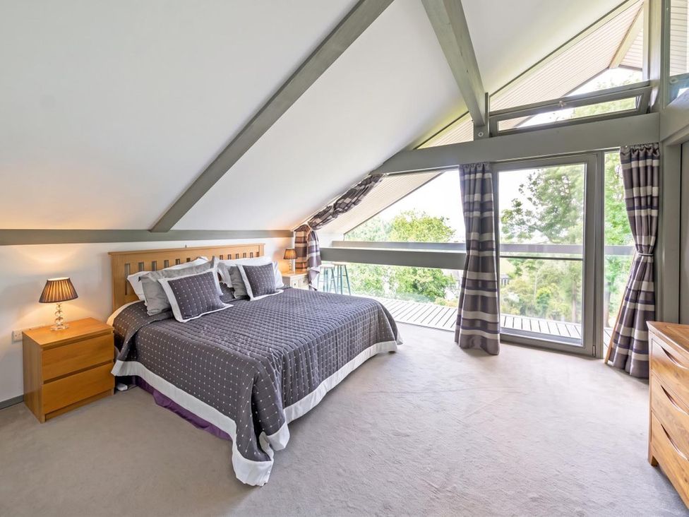 A bedroom with a bed and large windows at Two Hoots Littleworth