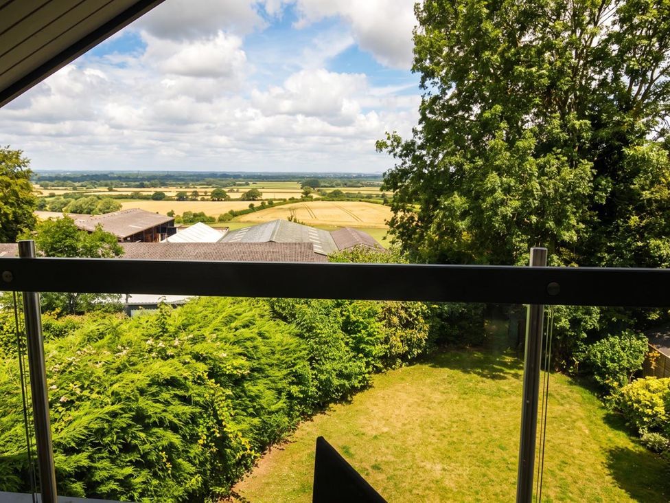 A view of fields and trees from a balcony at Two Hoots Littleworth