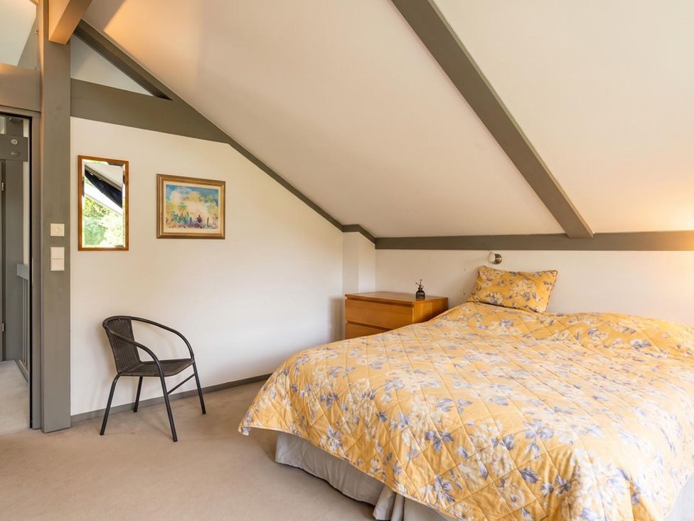 A bedroom with a bed, nightstand, and chair at Two Hoots Littleworth