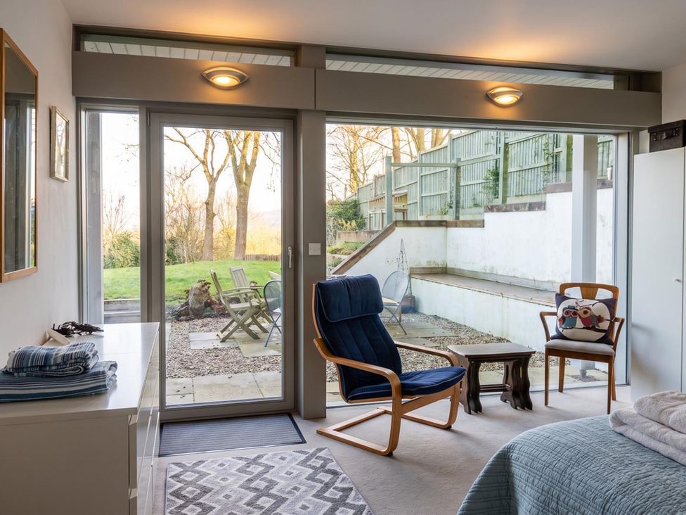 A bedroom with a sliding glass door and seating area at Two Hoots Littleworth