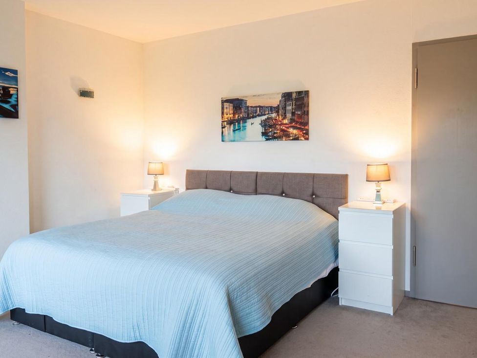 A bedroom with a bed and nightstands at Two Hoots Littleworth