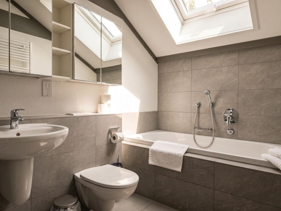 A bathroom with a sink, toilet, and bathtub at Two Hoots Littleworth