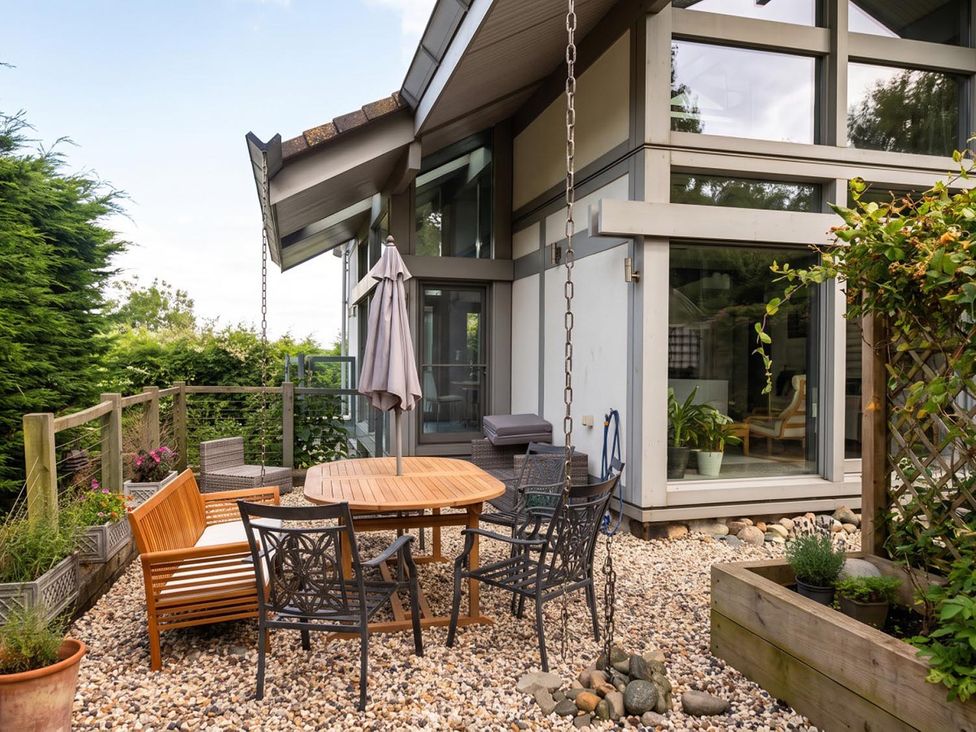 A garden with table and chairs under an umbrella at Two Hoots Littleworth