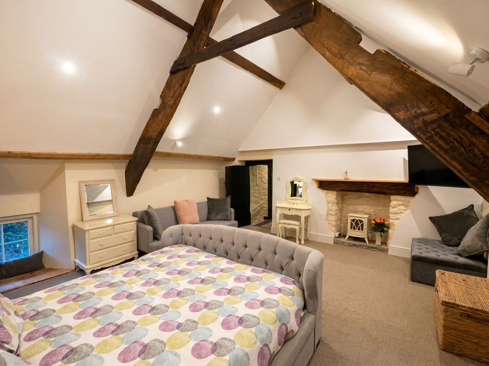A bedroom with a bed and dresser at Tynewydd Farmhouse