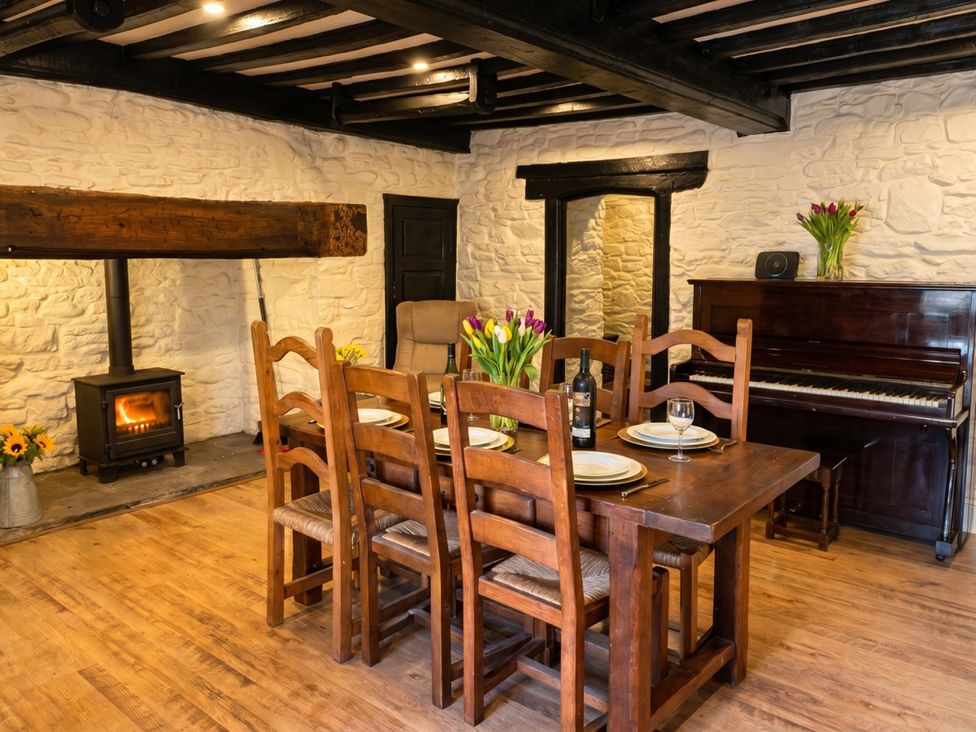 A dining room with a table and chairs at Tynewydd Farmhouse