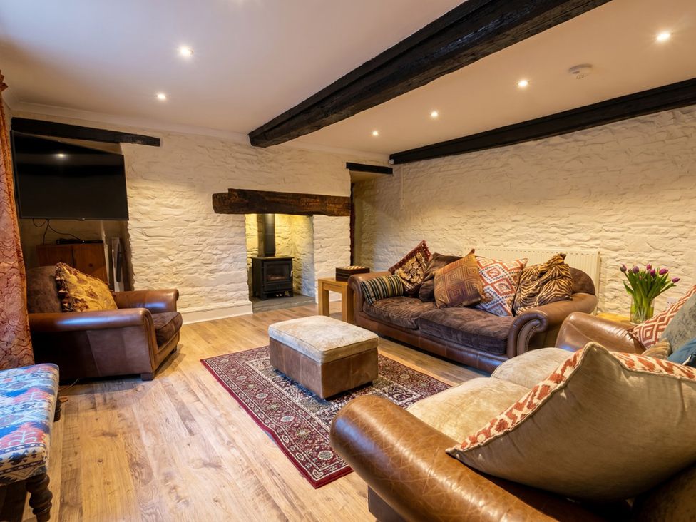 A living room with sofa and armchairs at Tynewydd Farmhouse