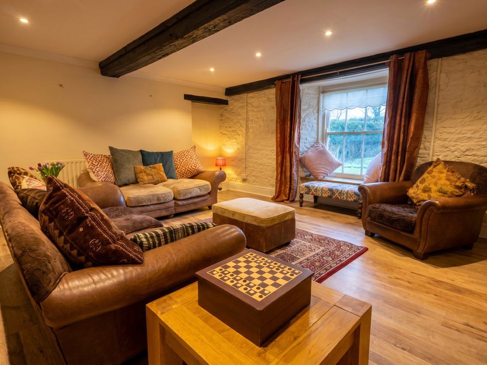 A living room with sofas and a coffee table at Tynewydd Farmhouse