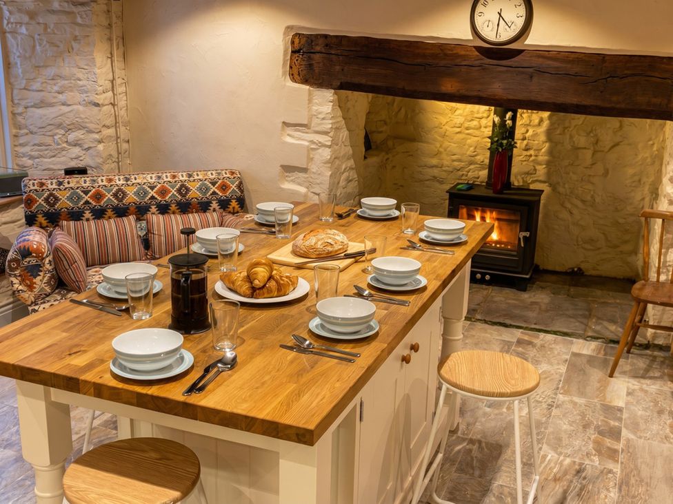 A kitchen with a dining table and sofa at Tynewydd Farmhouse