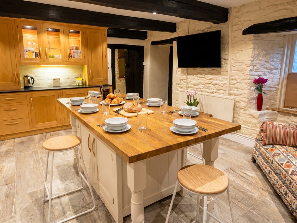 A kitchen with an island and seating at Tynewydd Farmhouse