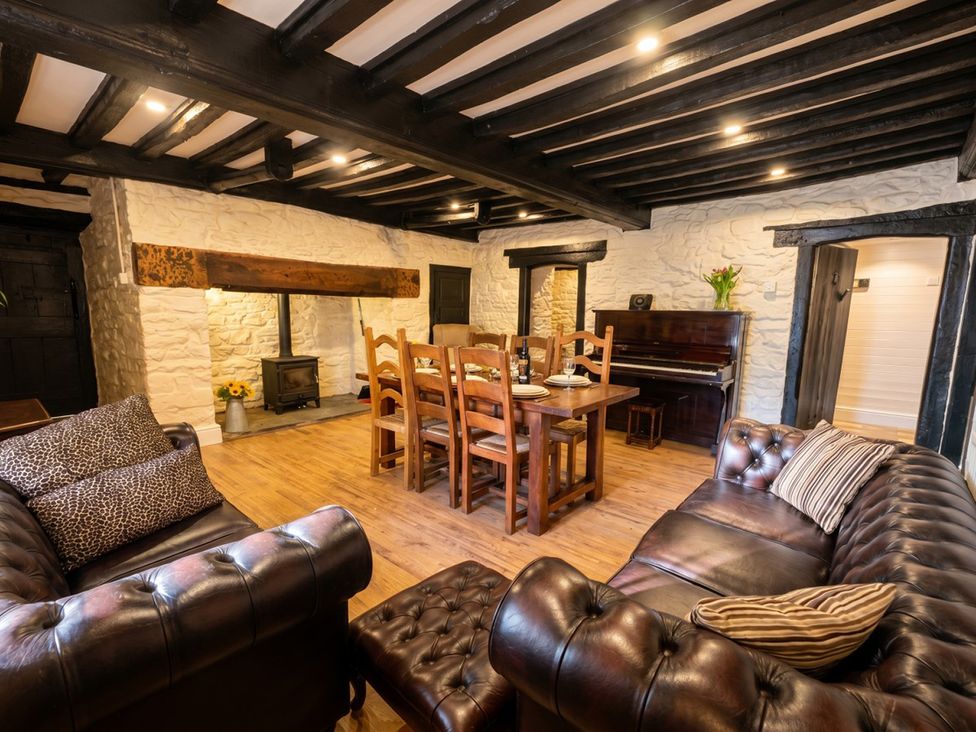 A dining room with a table and chairs at Tynewydd Farmhouse