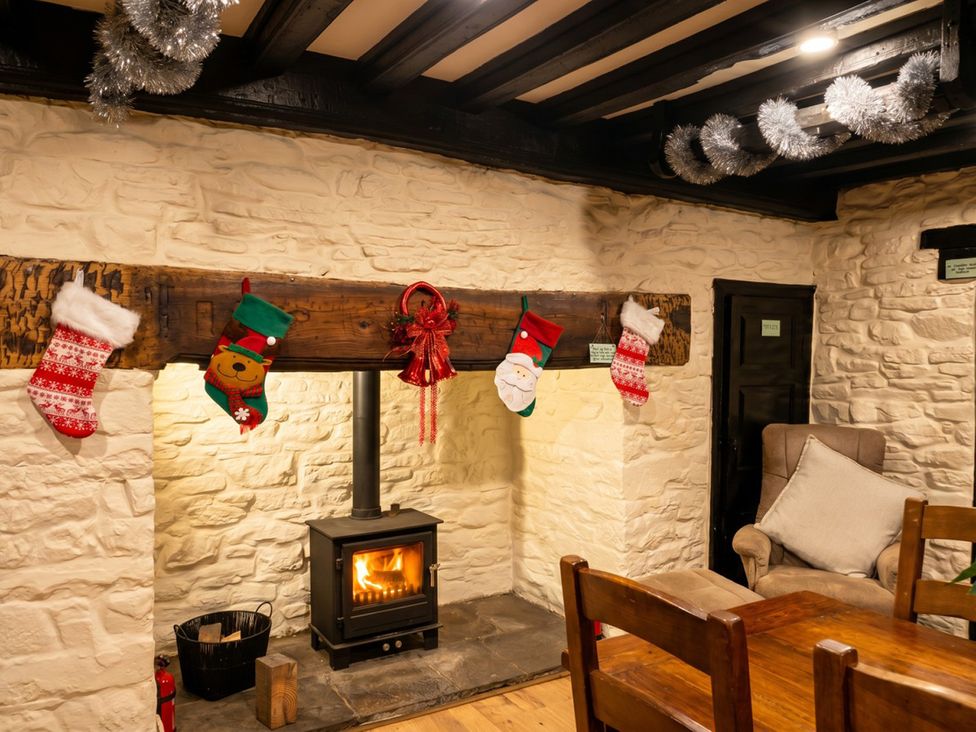 A living room with a fireplace and stockings at Tynewydd Farmhouse