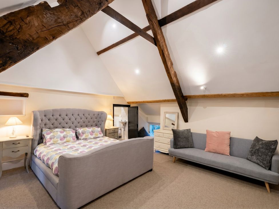 A bedroom with a bed and couch at Tynewydd Farmhouse