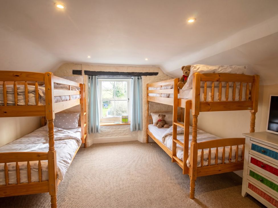 A bedroom with bunk beds and a window at Tynewydd Farmhouse