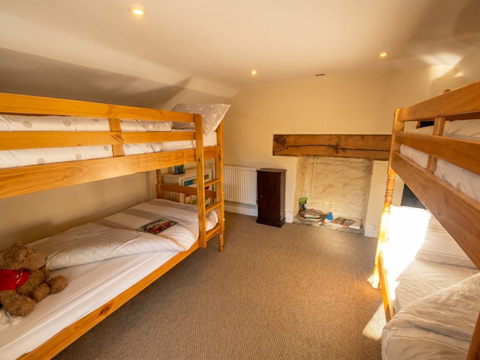 A bedroom with bunk beds and a teddy bear at Tynewydd Farmhouse