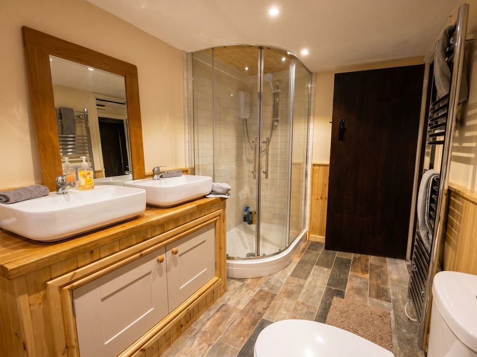 A bathroom with sinks and a shower at Tynewydd Farmhouse