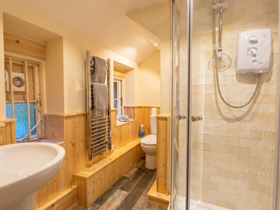 A bathroom with a shower and sink at Tynewydd Farmhouse