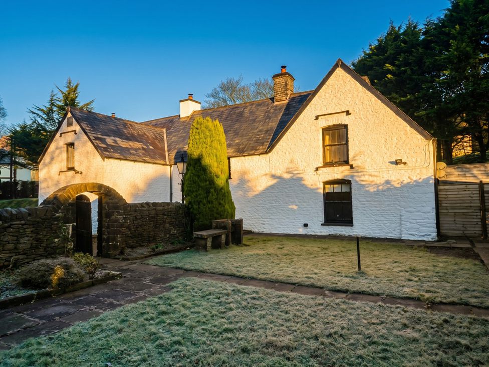 An outdoor view of a house with a garden path at Tynewydd Farmhouse