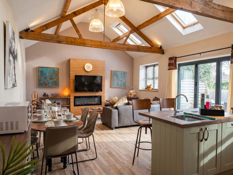 An open plan living area with a dining table and sofa at The Old Barn in Manchester