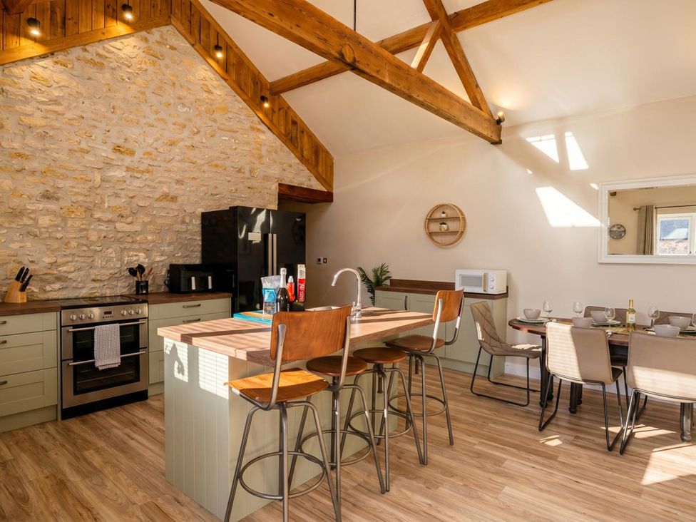 A kitchen with a stone wall and wooden beams at the property location