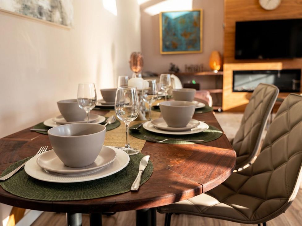 A dining room with a wooden table set for dinner at The Old Barn in Manchester