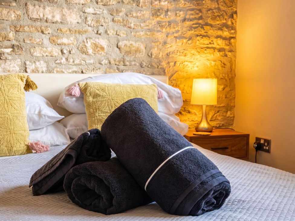 A bedroom with towels and pillows on a bed at The Old Barn in Manchester