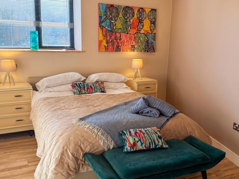 A bedroom with a bed and artwork on the wall at The Old Barn in Manchester