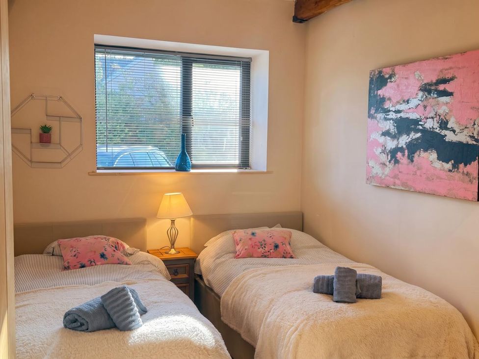 A bedroom with two beds and a lamp at The Old Barn in Manchester