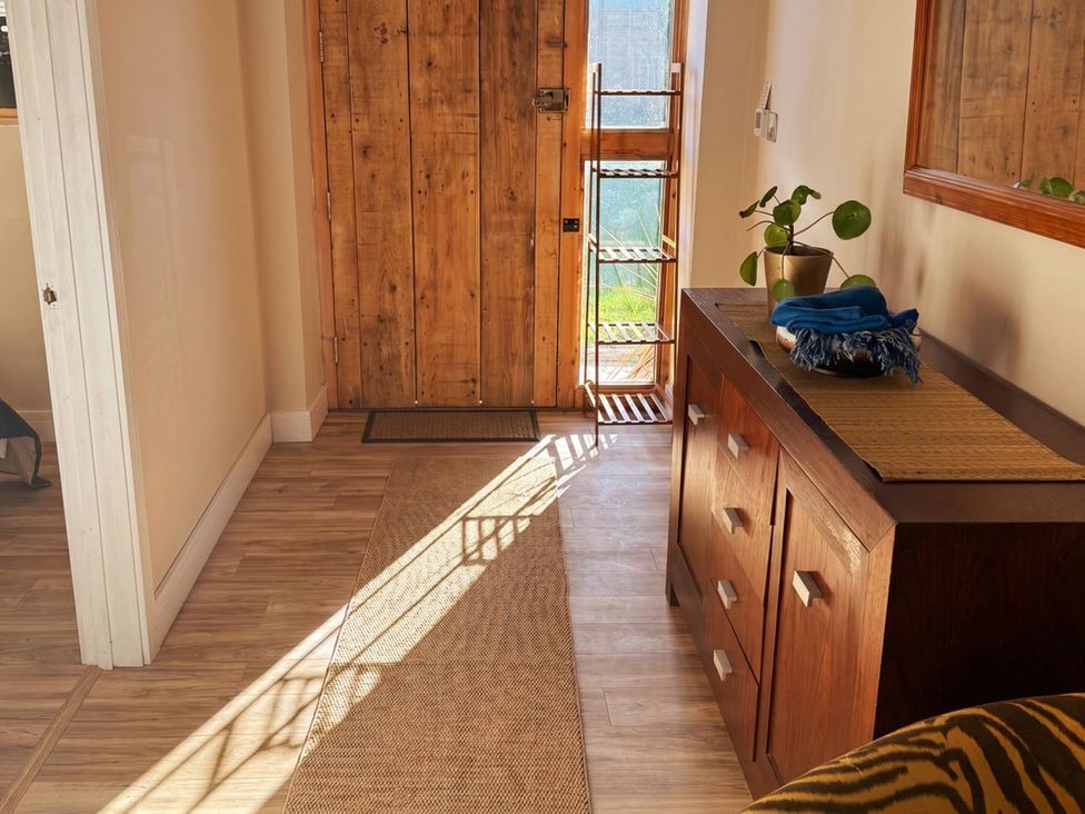 A hallway with a wooden door and console table at 