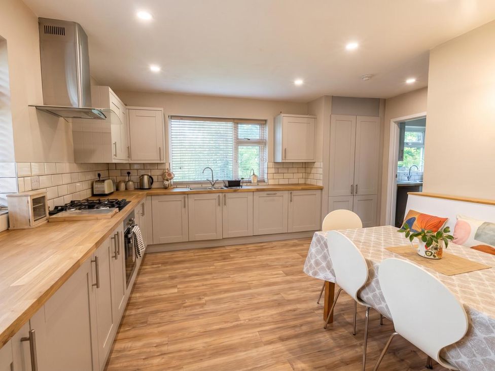 A kitchen with a gas stove, sink, and dining table at the property in location