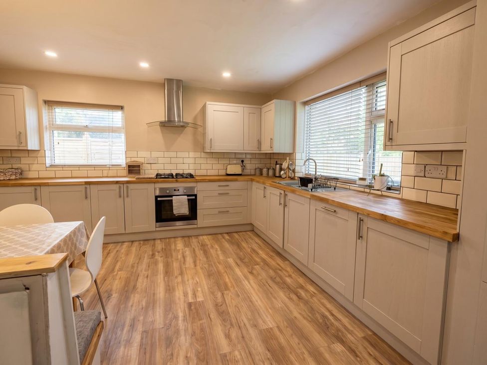 A kitchen with cabinets, sink, stove and table at The Old Barn in Manchester