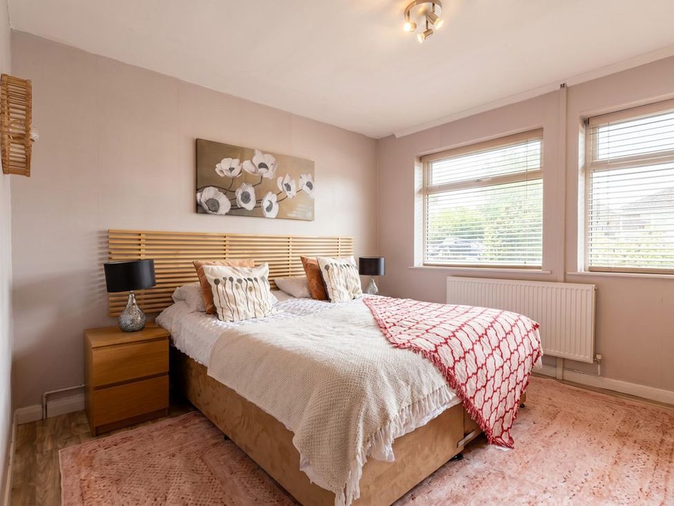 A bedroom with a bed and two windows at a property