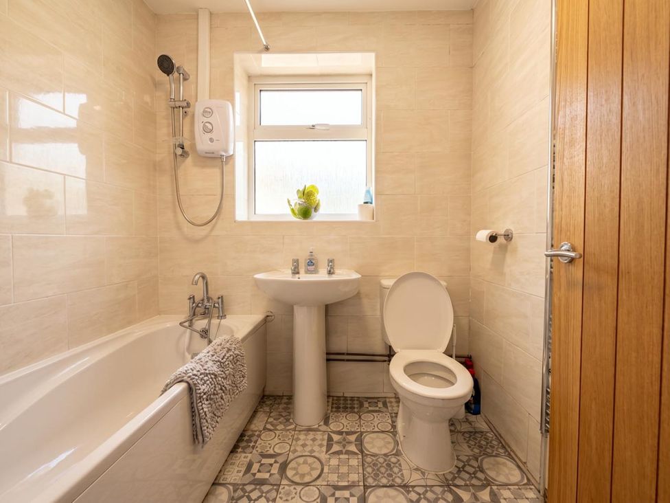 A bathroom with a bathtub, sink, and toilet at The Old Barn in Manchester