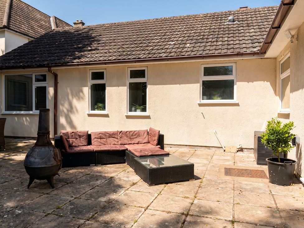 An outdoor seating area with a sofa, table, and chiminea at the property