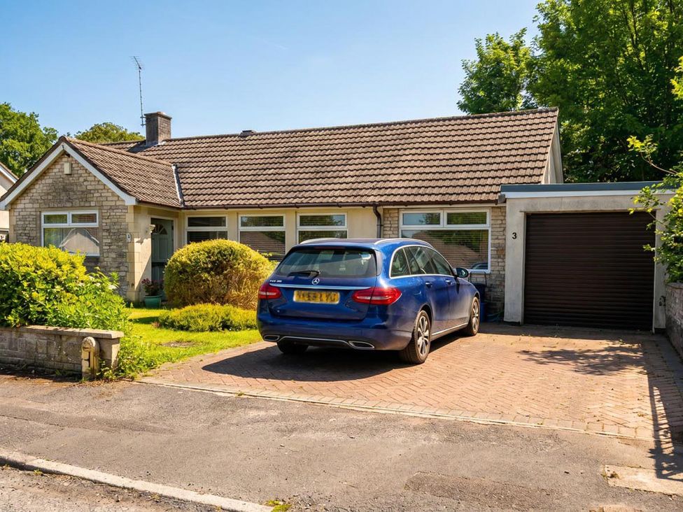 A house with a blue car parked in front at 3 Maple Road