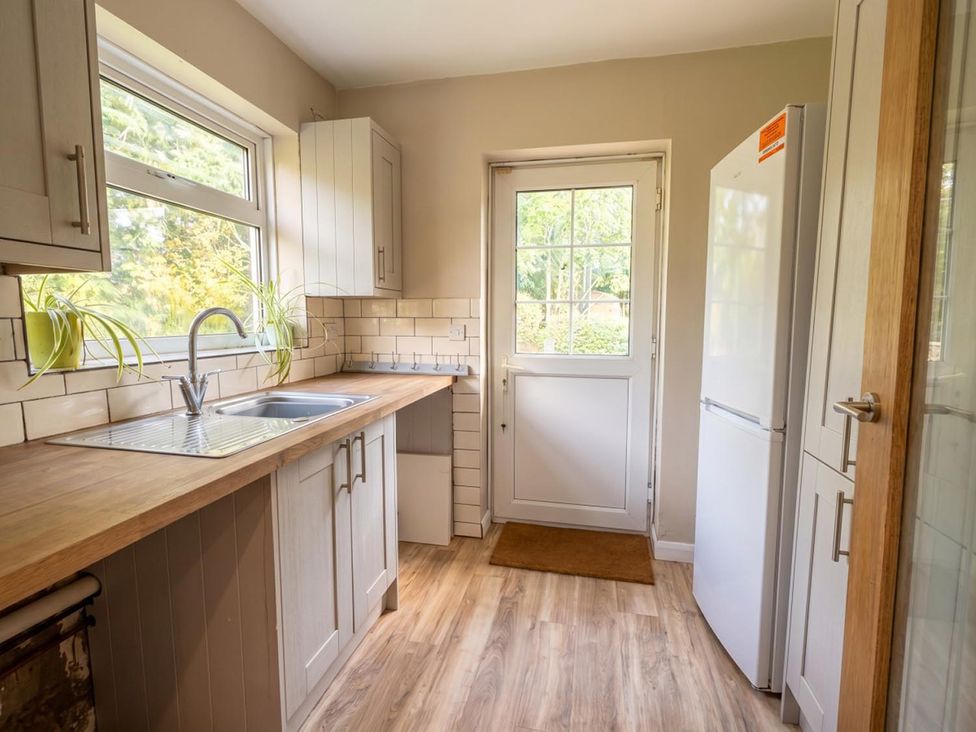 A kitchen with sink and refrigerator at the property in the location