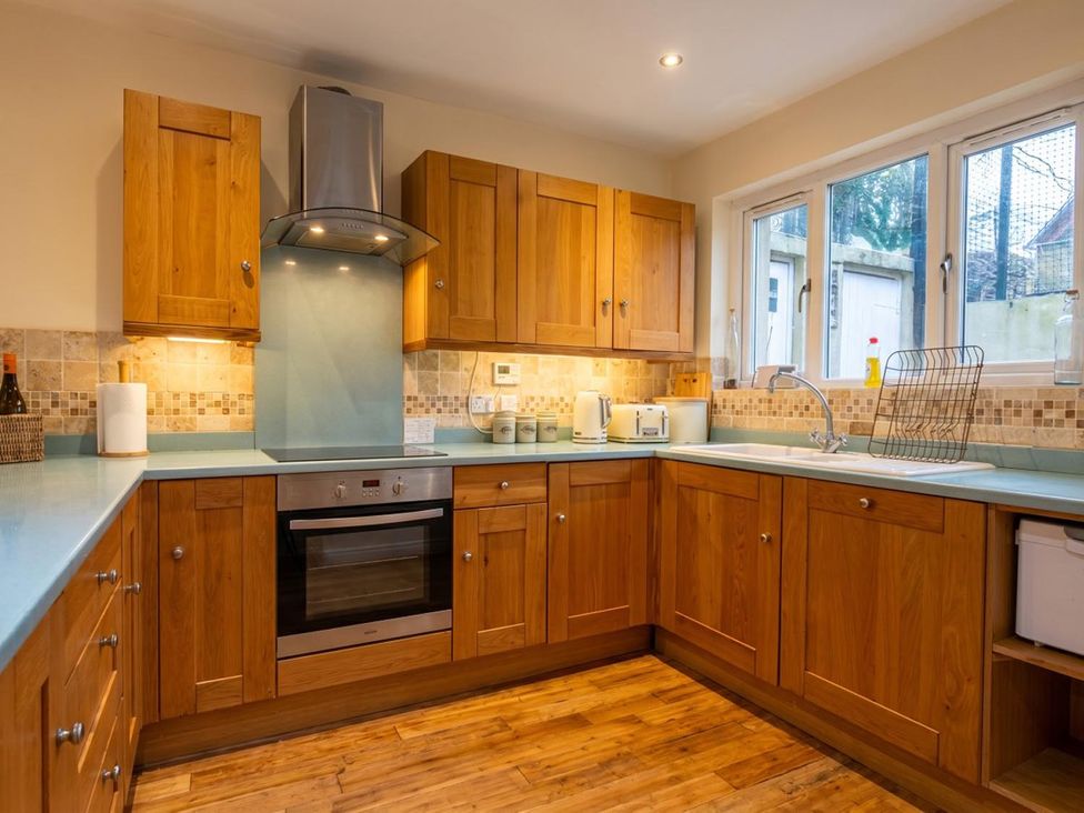 A kitchen with wooden cabinets and appliances at The Old Barn in Manchester
