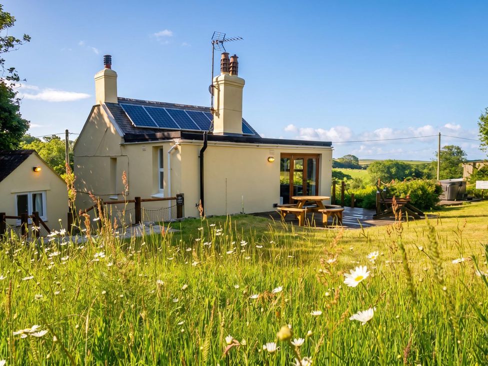 A house with solar panels and a table in the garden at 