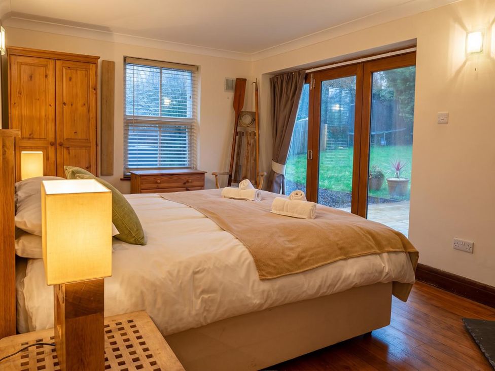 A bedroom with a bed and large windows at a property