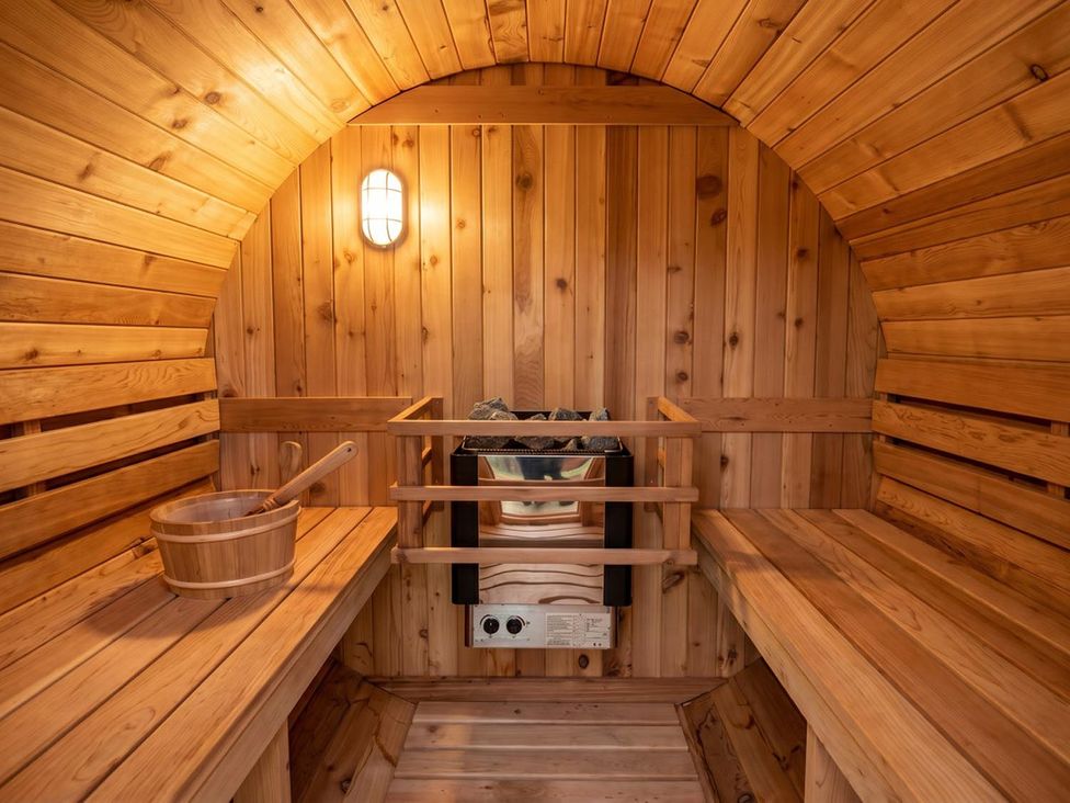 A sauna with wooden benches and a bucket at 