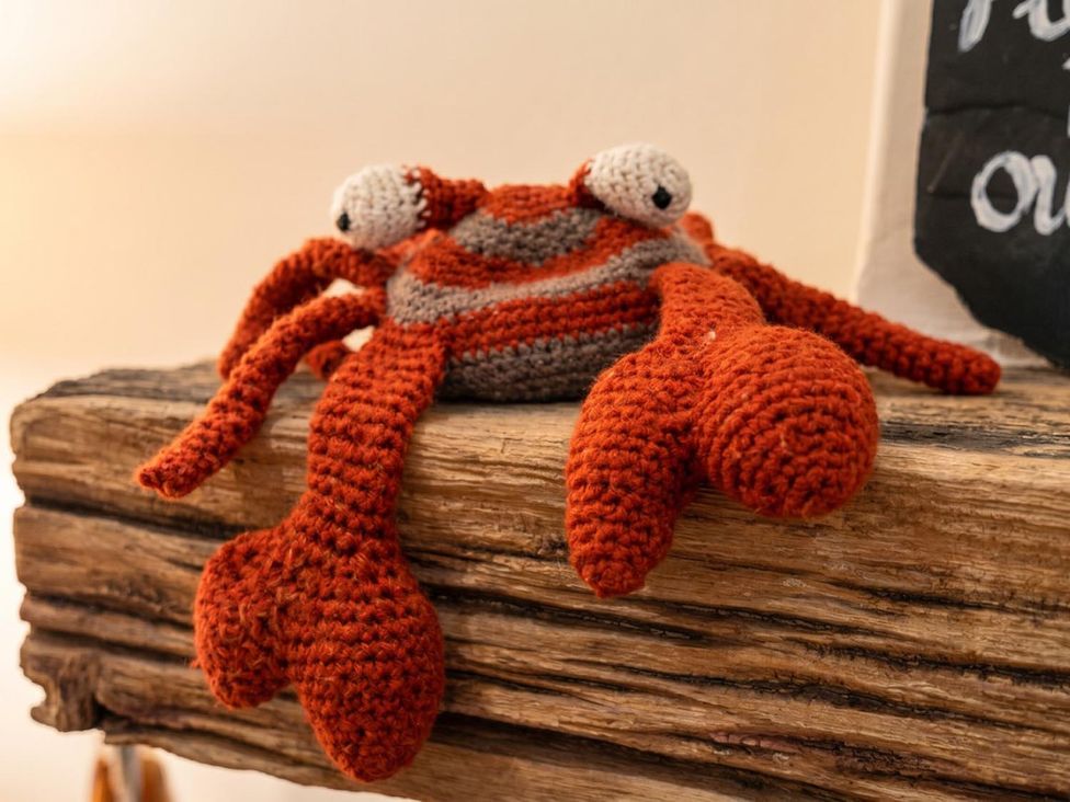 A crochet crab on a wooden surface