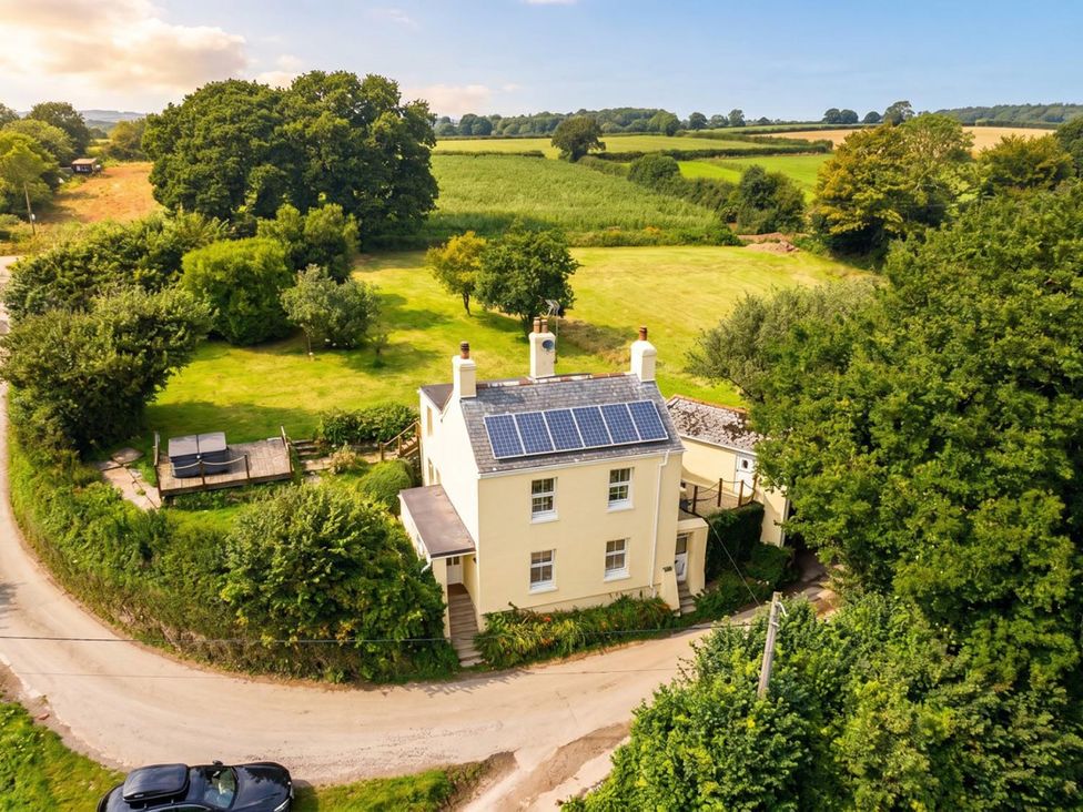 An aerial view of a house with solar panels and a garden at a property
