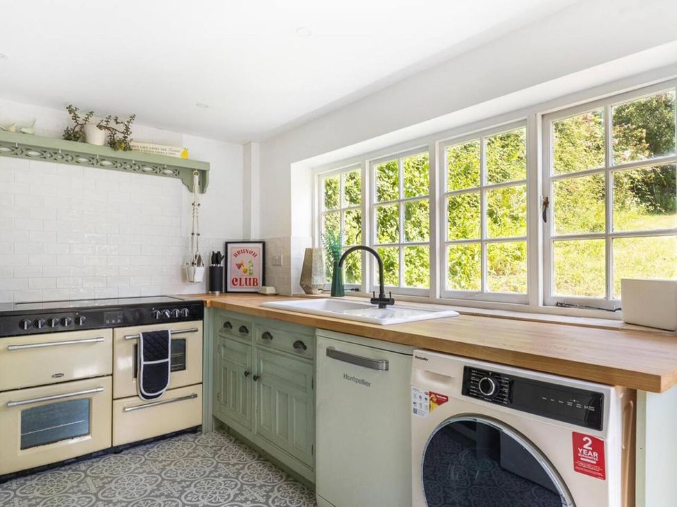 A kitchen with an oven, sink and window at The Old Barn in Manchester