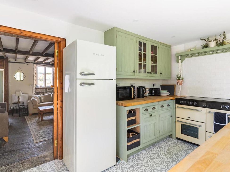 A kitchen with green cabinets and appliances at The Old Barn in Manchester