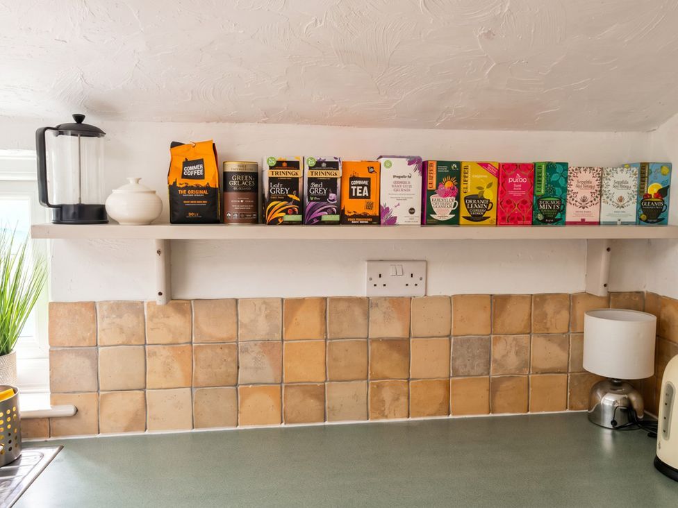 A kitchen with tea boxes and a coffee maker at the property in unspecified location