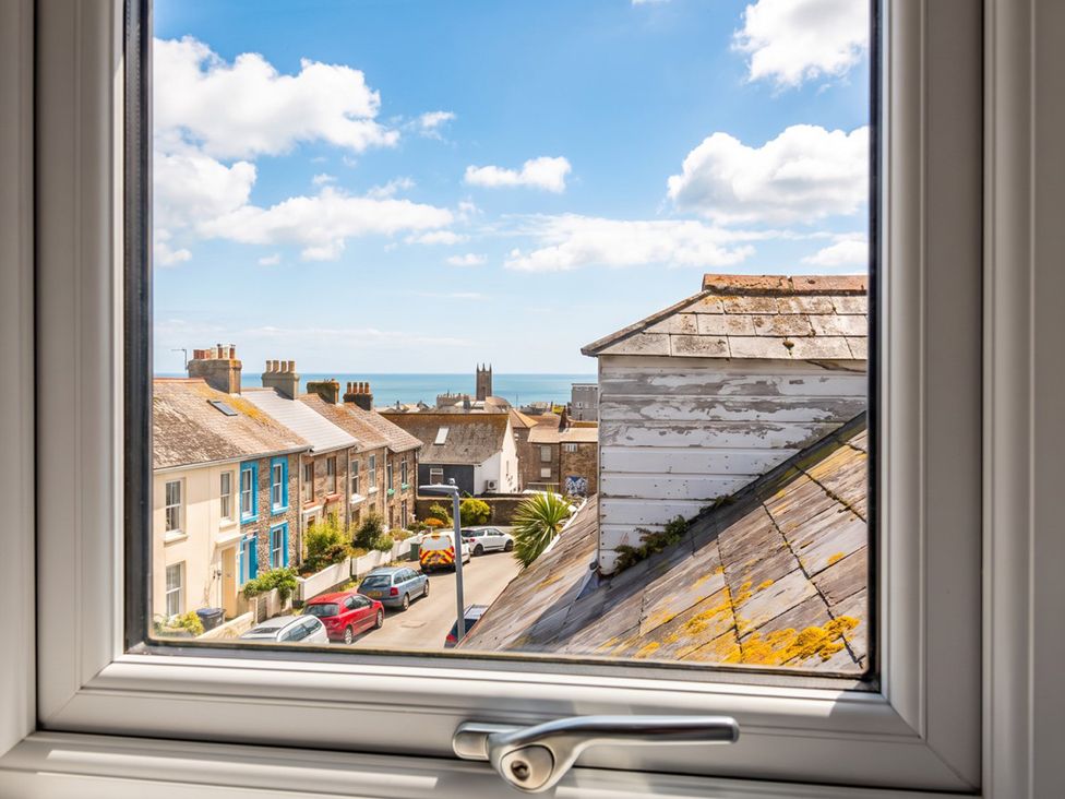 A view of houses and the sea from a window at seaside property