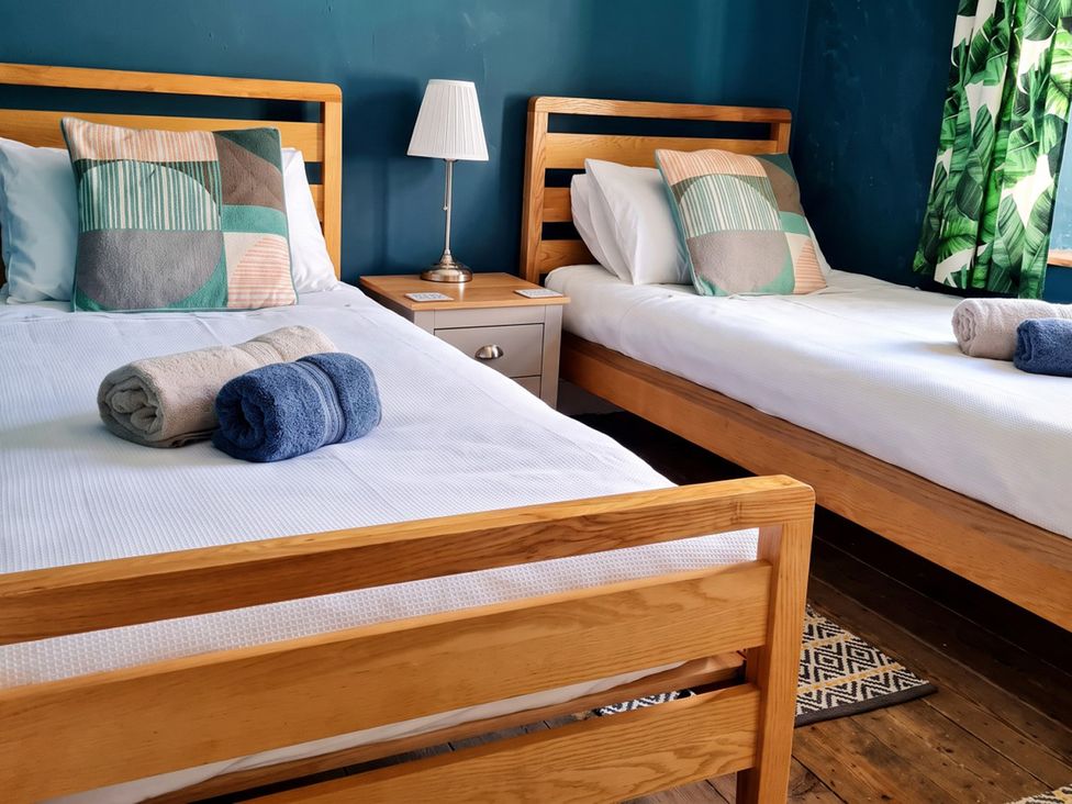A bedroom with two beds and towels on the beds at  
