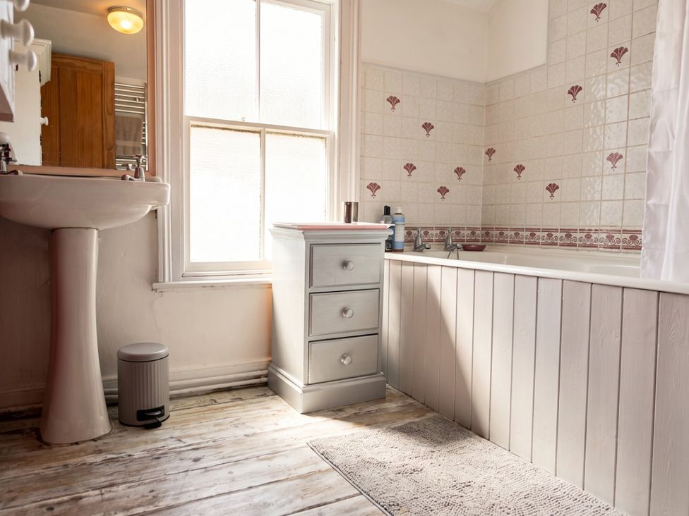 A bathroom with a bathtub, sink, and cabinet at The Old Barn in Manchester