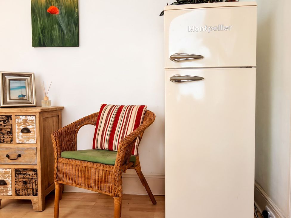 A living room with a refrigerator and a chair at 