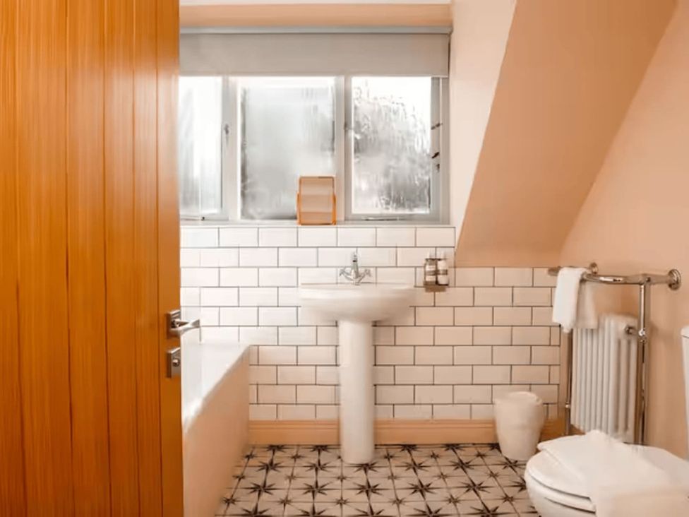 A bathroom with a sink, bathtub, and toilet at The Old Barn in Manchester